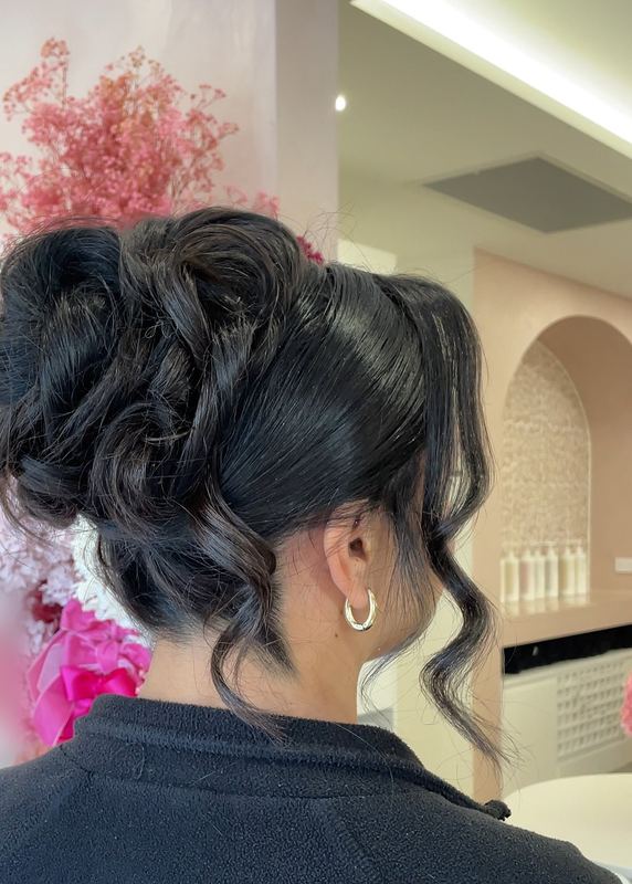 Voluminous curled bridal updo with soft tendrils