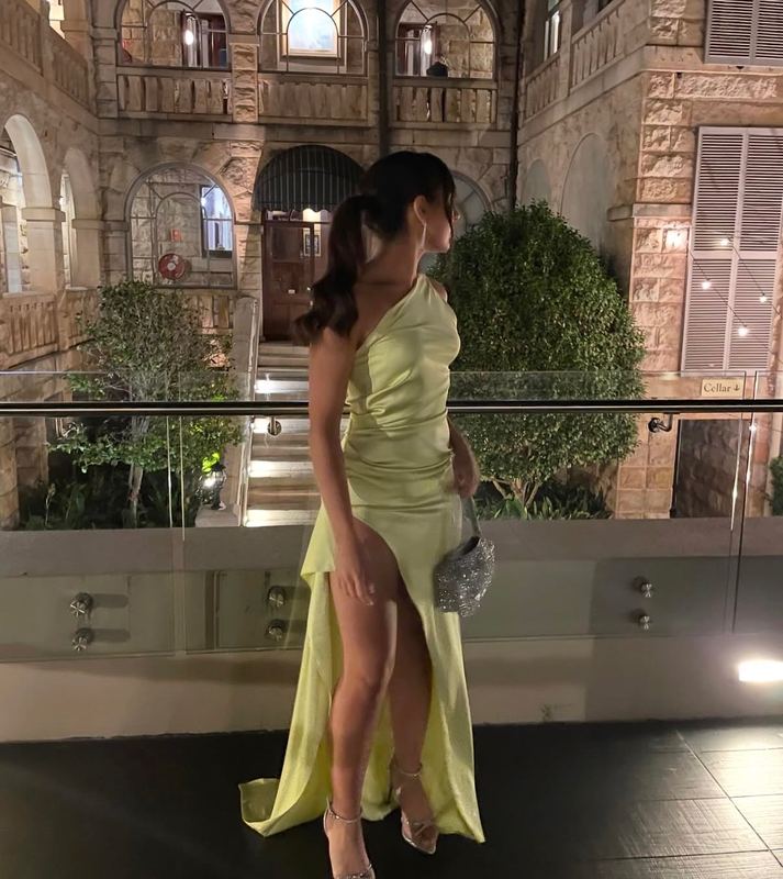 Guest in a lime satin gown with a sleek high ponytail