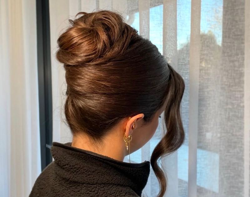 Sleek high updo with face framing pieces