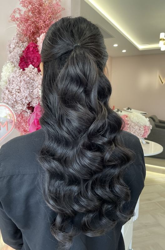 Voluminous half up ponytail with long, full curls