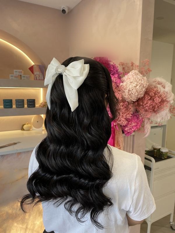 Long dark waves with a white satin bow